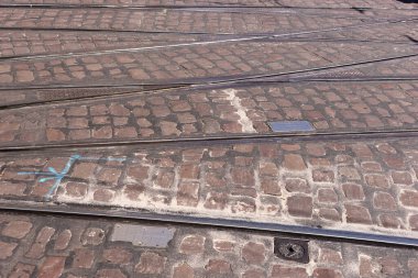 Şehir merkezinde kaldırım taşları arasında tramvay izleri var.
