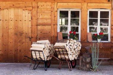 Soğuk günler için odun. Ahşap evin önündeki el arabasında.
