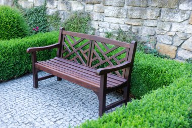 Bahçedeki boş ahşap bankta Her zaman yeşil bir çitin önünde