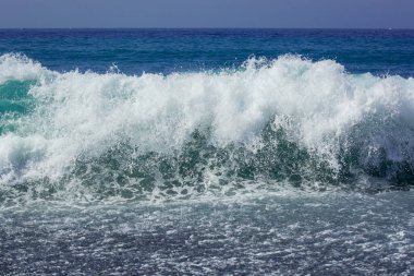 Volkanik siyah kumsal ve dalgaların resmi