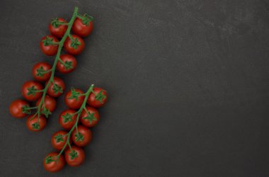 Siyah arka planda asmada vişne domatesleri