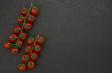 Siyah arka planda asmada vişne domatesleri