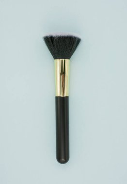 Mavi arkaplanda farklı boyutlarda makyaj fırçası