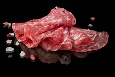 Parma jambonu, jambon ve siyah arka planda salam dilimleri.