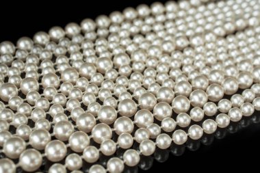 Siyah üzerine siyah beyaz bir inci kolye.