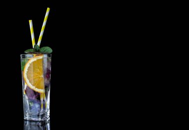 Buzlu bardak, soğuk su taze nane ve yenilebilir çiçekler. 