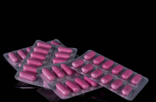 White medicine tablets isolated on black background