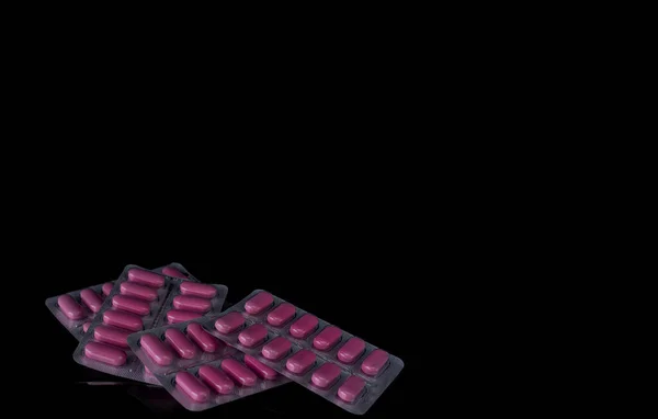 White medicine tablets isolated on black background