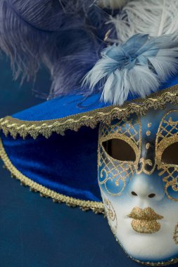 Image of delicate elegant venetian mask over blue background.
