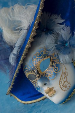 Image of delicate elegant venetian mask over blue background.