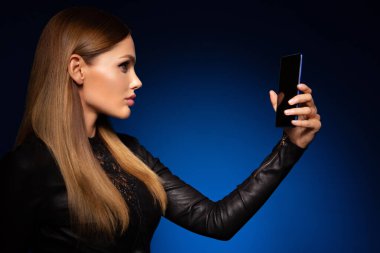 Beautiful woman handling phon. Bright makeup and beautiful hairstyle.