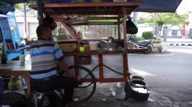 Soto (tavuk çorbası) satıcısı müşterisi için yemek hazırlıyor.