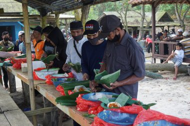 İnsanlar Cava Şükran Günü 'nde birlikte yemek yiyorlar. Sanggar sahilinde, Tulung Agung 'da, Doğu Java' da, Endonezya 'da, Sedekah Bumi' de yemek yiyen insanlar var.