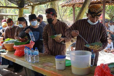 İnsanlar Cava Şükran Günü 'nde birlikte yemek yiyorlar. Sanggar sahilinde, Tulung Agung 'da, Doğu Java' da, Endonezya 'da, Sedekah Bumi' de yemek yiyen insanlar var.