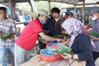 İnsanlar Cava Şükran Günü 'nde birlikte yemek yiyorlar. Sanggar sahilinde, Tulung Agung 'da, Doğu Java' da, Endonezya 'da, Sedekah Bumi' de yemek yiyen insanlar var.