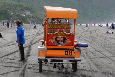 Parang Tritis plajı, Yogyakarta 'da bir at tarafından çekilmiş yolcu bekliyor. Endonezyalılar buna Dokar, Delman veya andong der.