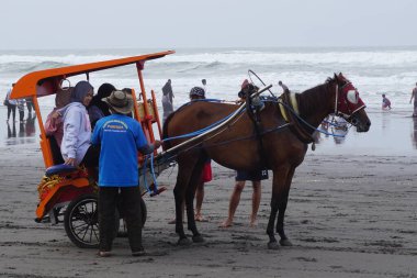 Parang Tritis plajı, Yogyakarta 'da bir at tarafından çekilmiş yolcu bekliyor. Endonezyalılar buna Dokar, Delman veya andong der.