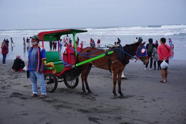 Parang Tritis plajı, Yogyakarta 'da bir at tarafından çekilmiş yolcu bekliyor. Endonezyalılar buna Dokar, Delman veya andong der.