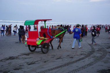 Parang Tritis plajı, Yogyakarta 'da bir at tarafından çekilmiş yolcu bekliyor. Endonezyalılar buna Dokar, Delman veya andong der.