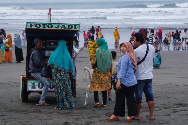 İnsanlar Parang Tritis plajında, Yogyakarta 'da, Endonezya' da tatil yapıyorlar.