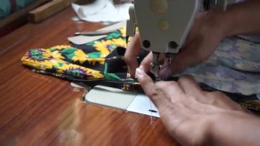 Birinin eli gömlek dikiyor.