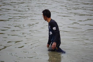 İnsanlar Gropyok iwak 'ta balık tutuyor. Gropyok iwak, geleneksel araçlarla birlikte balık avlamak anlamına geliyor.