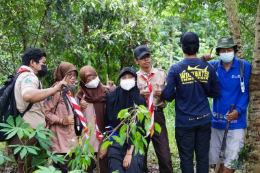 Bazı insanlar ormanı yeniden ağaçlandırıyor ve küresel ısınmayı azaltmak için bazı bitkiler getiriyorlar.