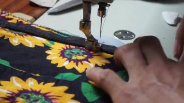 Birinin eli gömlek dikiyor.