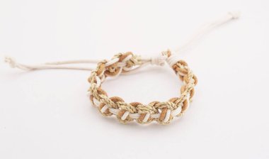 Beyaz arka planda izole bir etnik bilezik. Bilezik çeşitli iplerden yapılmış.