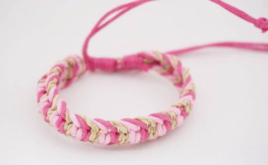 Beyaz arka planda izole bir etnik bilezik. Bilezik çeşitli iplerden yapılmış.