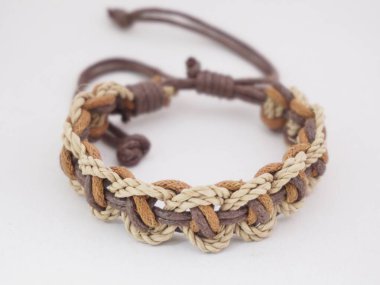 Beyaz arka planda izole bir etnik bilezik. Bilezik çeşitli iplerden yapılmış.