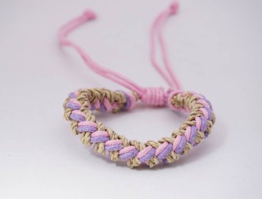 Beyaz arka planda izole bir etnik bilezik. Bilezik çeşitli iplerden yapılmış.