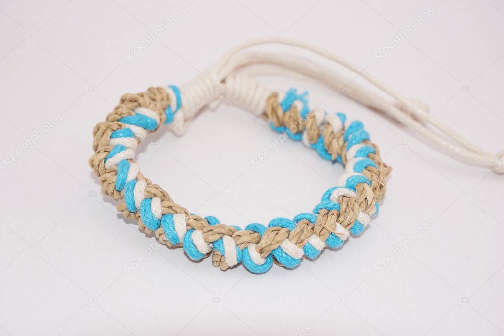 An isolated ethnic bracelet on white background. The bracelet is made off the various rope