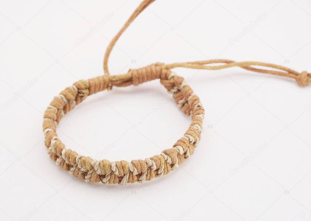 An isolated ethnic bracelet on white background. The bracelet is made off the various rope