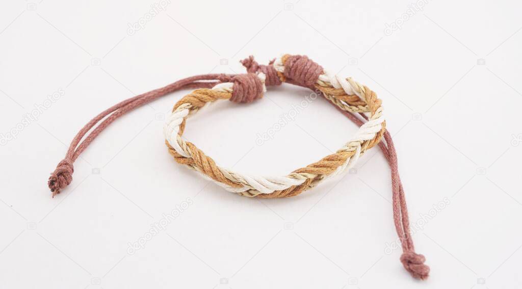 An isolated ethnic bracelet on white background. The bracelet is made off the various rope