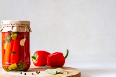 Hafif arka planda ev yapımı kırmızı biber turşusu. Sebze koruma, mevsimlik hasat. Boşluğu kopyala, metin için yer.