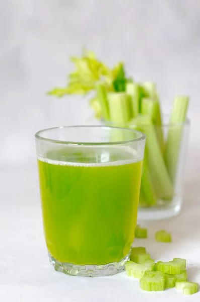 Зеленый, свежий, здоровый сельдерей сок в стакане на белом фоне. Крупный план. — стоковое фото