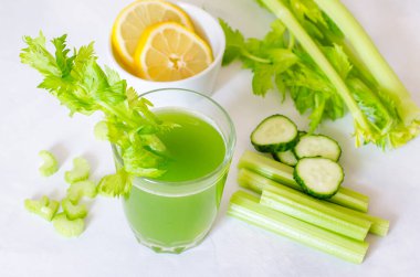 Yeşil taze kereviz ve limonlu salatalık suyu. Sağlıklı bir içecek, beyaz arka planda bir bardak içki. Detoks diyeti, saf organik gıda, sebzeli..
