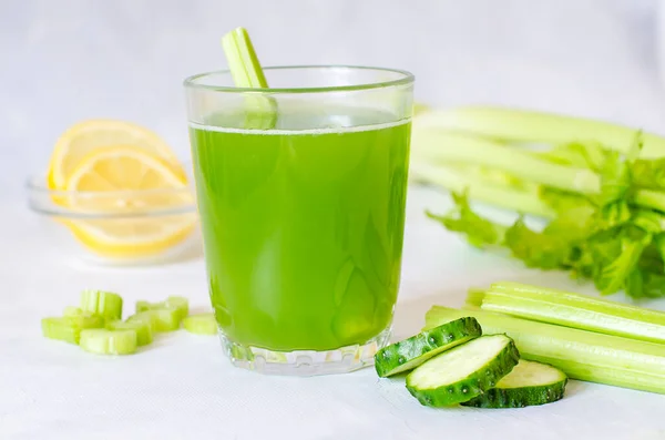 Зеленый свежий сельдерей и огуречный сок с добавлением лемоньих лаймтизаторов. Ингредиенты для здорового напитка, стакан напитка на белом фоне. Детоксикационная диета, чистая органическая пища, с овощами. — стоковое фото