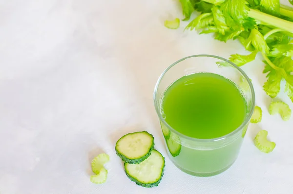 Verse selderij en komkommer sap. Groene gezonde drank in een glas op een witte achtergrond. Detox dieet, puur biologisch voedsel, met groenten. — Stockfoto