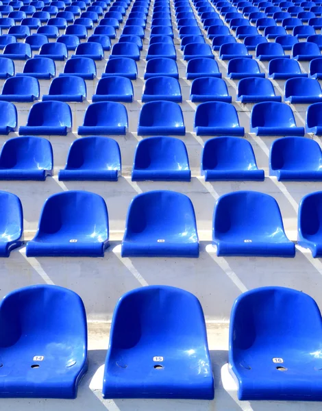 Sedie di plastica blu su una tribuna dello stadio — Foto Stock