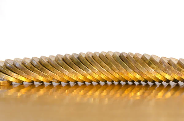 Ряд монет, лежащих на золотой поверхности — стоковое фото