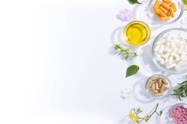 Beyaz zemin üzerinde izole edilmiş çeşitli vitamin kapsüllerinin ve beslenme takviyelerinin düz konumu.