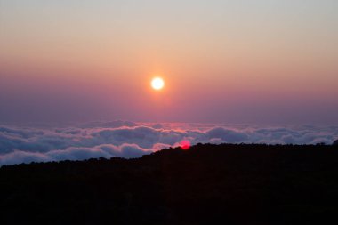 Lens aleviyle lokum bulutlarının üzerinde gün batımı