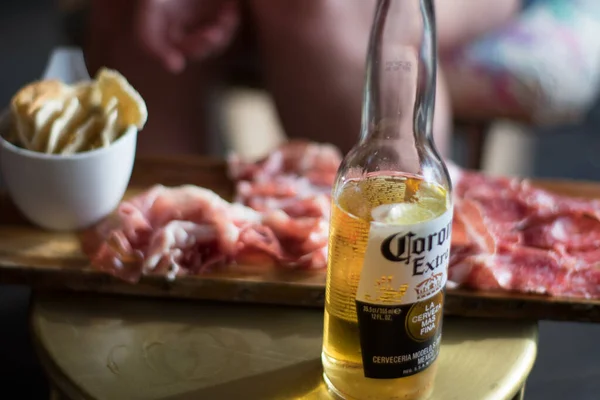 Corona şişesi taze şarküterinin önünde.