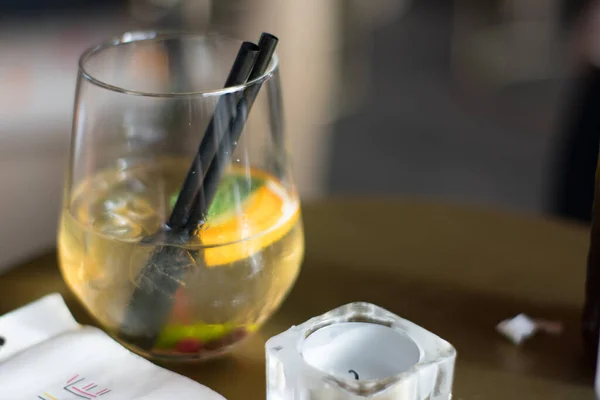 Küçük mumun yanındaki masada taze limon kokteyli.