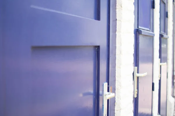 Bir tren istasyonunda mavi kapıları beyaz tuğladan duvara kapatın..