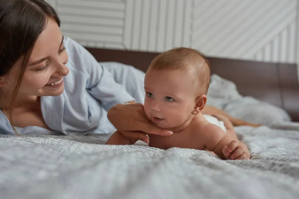 Close-up portret speelse jonge moeder kietelen zoete baby — Stockfoto