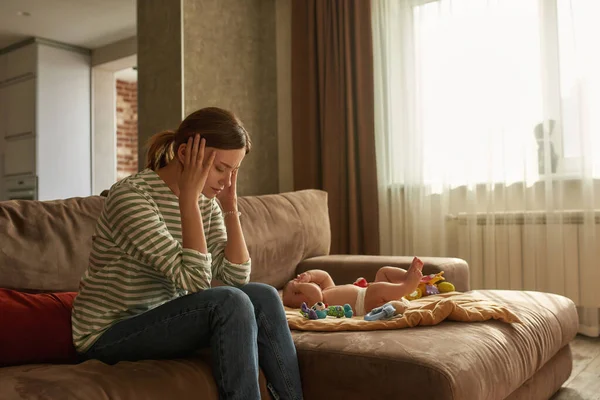 Young mother suffering from chronic headache caused by instant baby crying — Stock Photo, Image