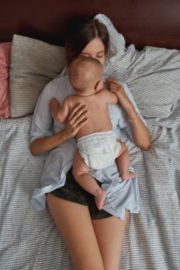 Güzel bebek annesinin vücudunda sürünüyor.